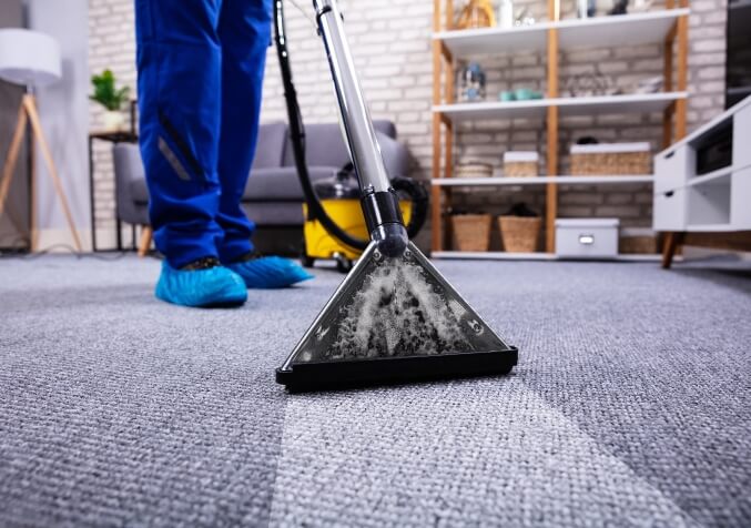 Worker Cleaning Carpet with Hot Water Extraction Machine